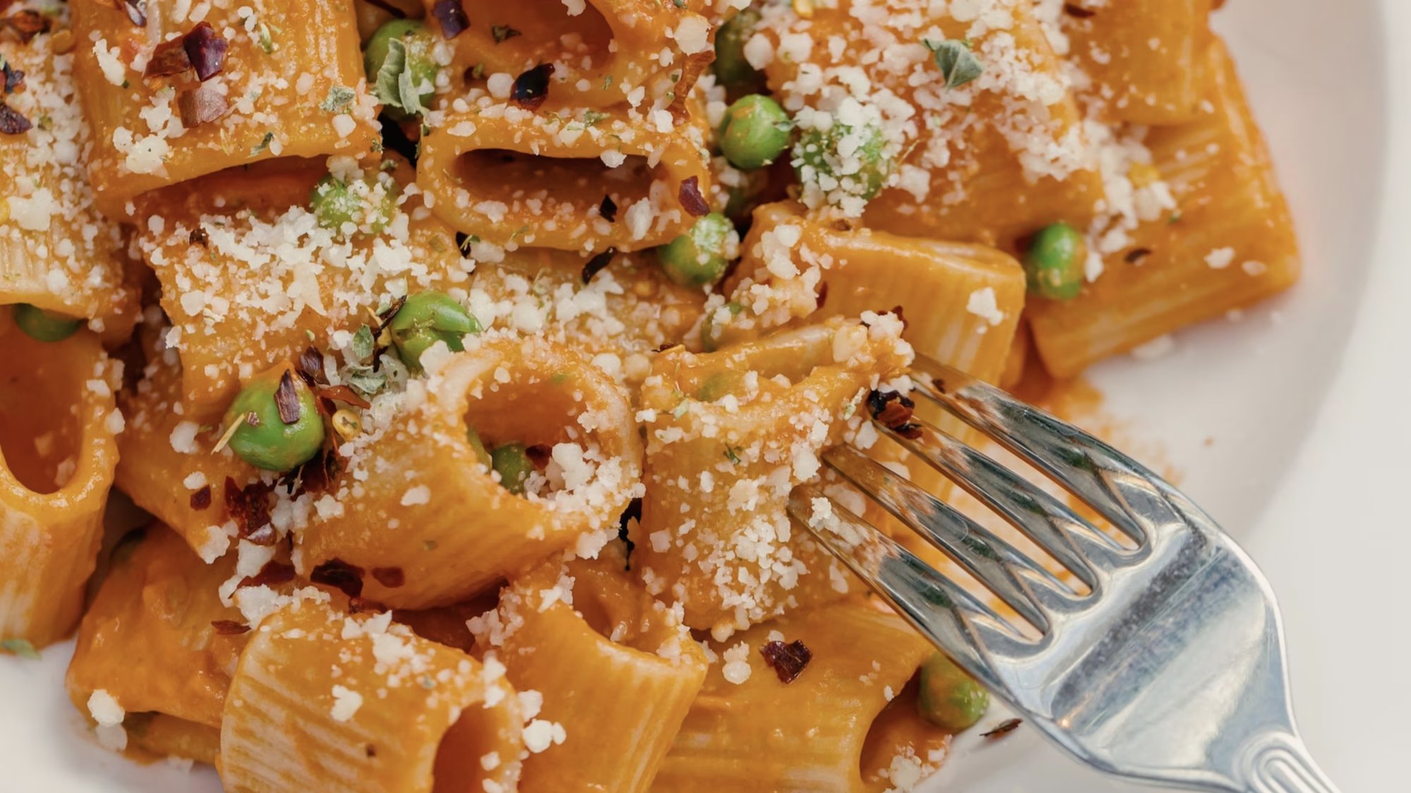 spicy rigatoni pasta with red sauce and peas